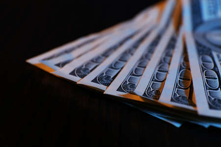 One hundred dollars banknotes on wooden table backgroundの写真素材