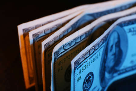One hundred dollars banknotes on wooden table backgroundの写真素材