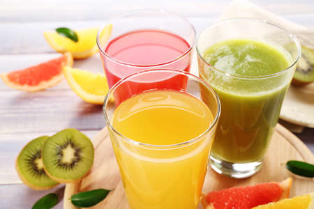 Fresh juices with fruits on wooden tableの写真素材