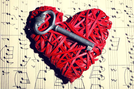Retro key with wicker heart on music book backgroundの写真素材