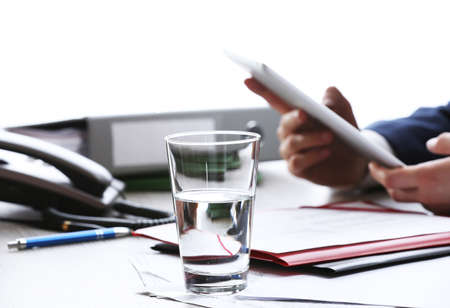 Businessman working at table in office on white blurred backgroundの写真素材