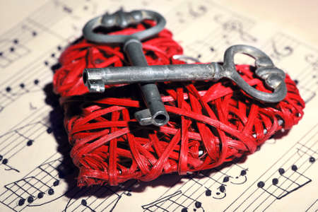 Retro keys with wicker heart on music book backgroundの写真素材