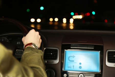 Man driving his modern car at night in city, close-upの写真素材