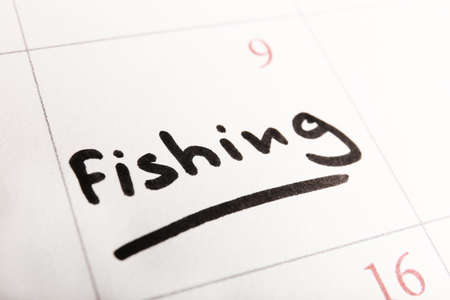 Written plan Fishing on calendar page backgroundの写真素材