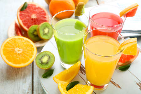 Fresh juices with fruits on wooden tableの写真素材