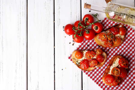 Slices of white toasted bread with butter and canned tomatoes on wooden backgroundの写真素材