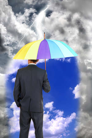 Business man standing in rain with umbrellaの写真素材
