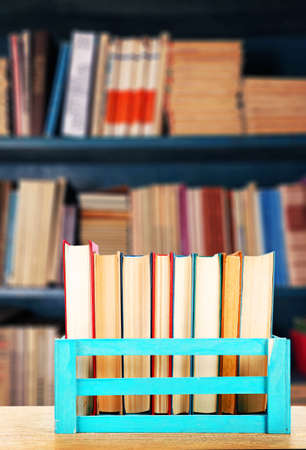 Books in wooden crate on bookshelves backgroundの写真素材