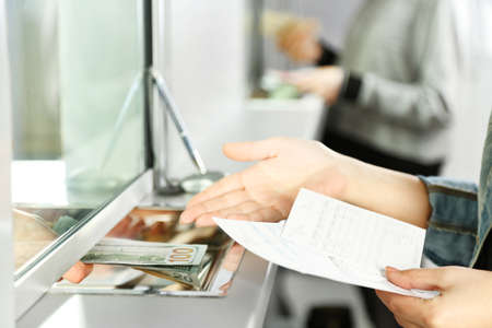 Female hand with money in cash department window. Currency exchange conceptの写真素材