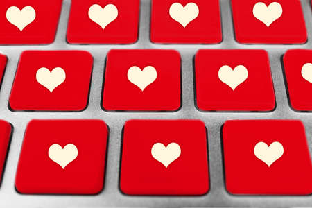 Close up of laptop keyboard with hearts iconsの写真素材