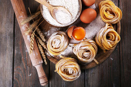 Raw homemade pasta and ingredients for pasta on wooden backgroundの写真素材