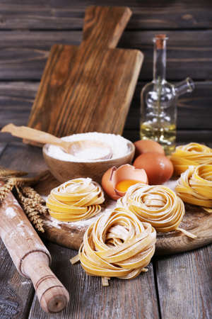 Raw homemade pasta and ingredients for pasta on wooden の写真素材