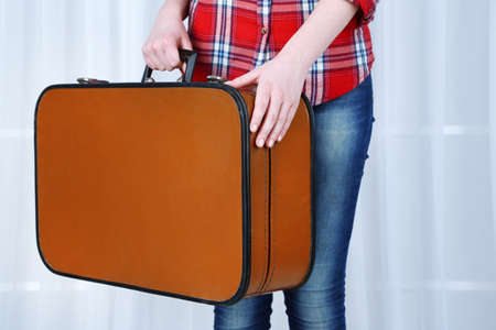 Woman holding old suitcase on fabric の写真素材
