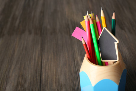 Colorful pencils with paper notes in holder on wooden table の写真素材