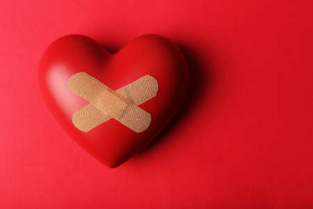 Heart with plaster on colorful backgroundの写真素材