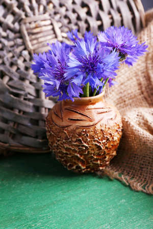 Beautiful cornflowers in vase on wooden backgroundの写真素材