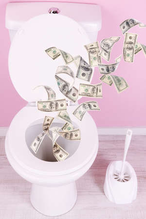 A lot of money is flushed down the toilet.の写真素材