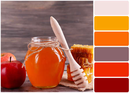 Delicious honey with apple on table and palette of colorsの写真素材