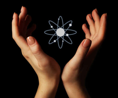 Hands with atom image, on black backgroundの写真素材