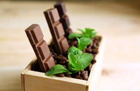Still life with set of chocolate in wooden box of coffee grains on wooden backgroundの写真素材
