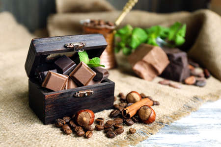 Still life with set of spicy chocolate, nuts and coffee beans on burlap cloth, closeupの写真素材