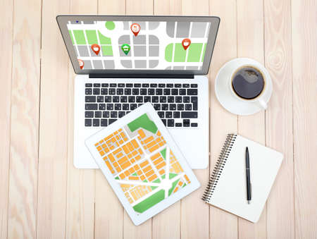 Laptop and tablet with map gps navigation application on wooden tableの写真素材