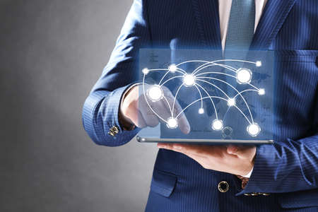 Businessman holding tablet-pc with social network structure Businessman holding tablet-pc with social network structure