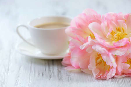 Pink tulips with cup of coffee on wooden backgroundの写真素材