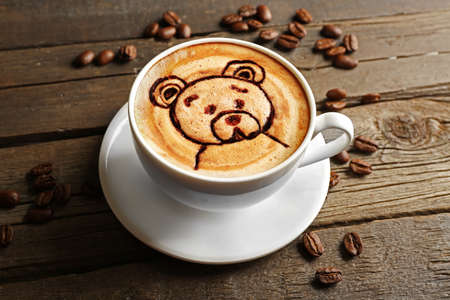 Cup of latte art coffee with grains on wooden backgroundの写真素材