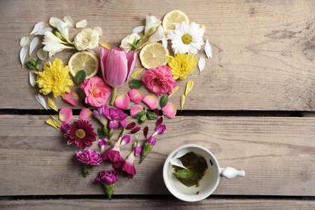 Cup of herbal tea with beautiful flowers, on wooden backgroundの写真素材