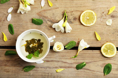 Cup of herbal tea with beautiful flowers, on wooden backgroundの写真素材