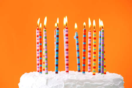 Birthday cake with candles on color backgroundの写真素材