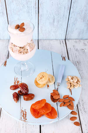 Glass of cream with oatmeal and almonds on color wooden backgroundの写真素材