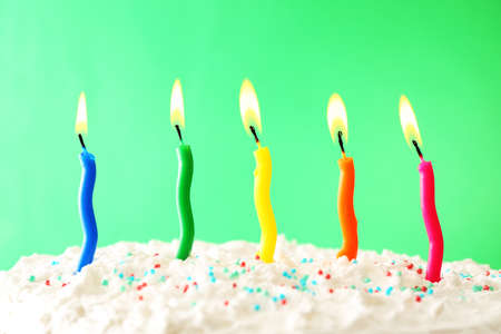 Birthday cake with candles on color backgroundの写真素材