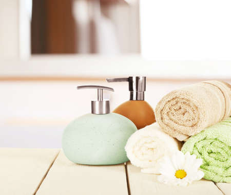 Soft towels with dispenser and flower in bathroomの写真素材