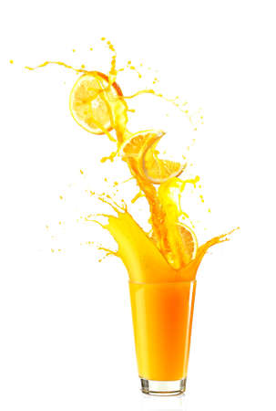 Juice splash in glass with orange slices isolated on whiteの写真素材
