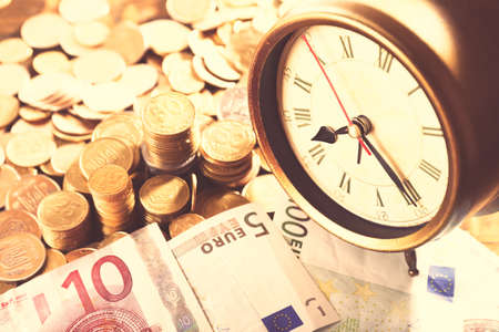 Money and alarm clock, closeupの写真素材