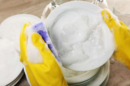 Female hand washing dish close upの写真素材