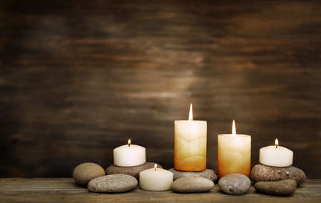 Beautiful composition with candles and spa stones on wooden backgroundの写真素材