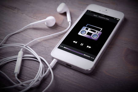 Mobile phone and earphones on wooden backgroundの写真素材