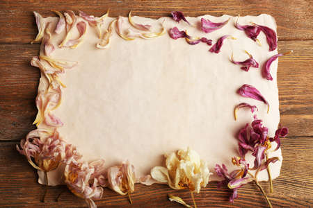 Dried flowers on sheet of paper on wooden table, top viewの写真素材