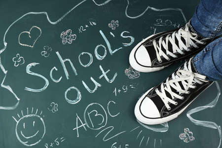 Female feet on blackboard background with inscriptions and sketchesの写真素材