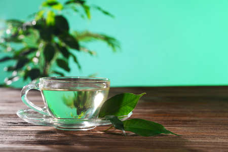 Cup of green tea on table on green backgroundの写真素材