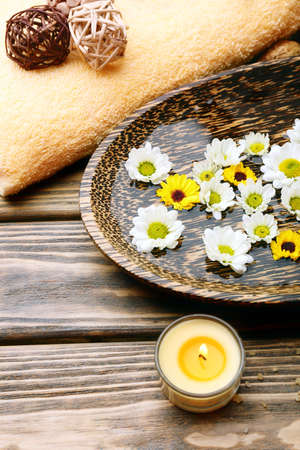 Candles with flowers on plate on table close upの写真素材