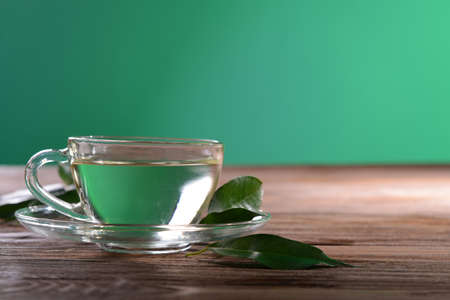 Cup of green tea on table on green backgroundの写真素材