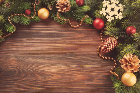 Christmas fir tree branches with toys on wooden tableの写真素材