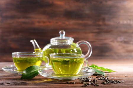 Cups of green tea on table on wooden backgroundの写真素材