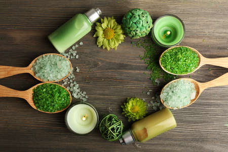 Beautiful composition with sea salt in wooden spoons and flowers on table close upの写真素材