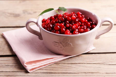 Red currant in bowl on wooden backgroundの写真素材