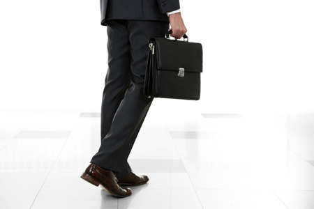Man holding suitcase on light backgroundの写真素材